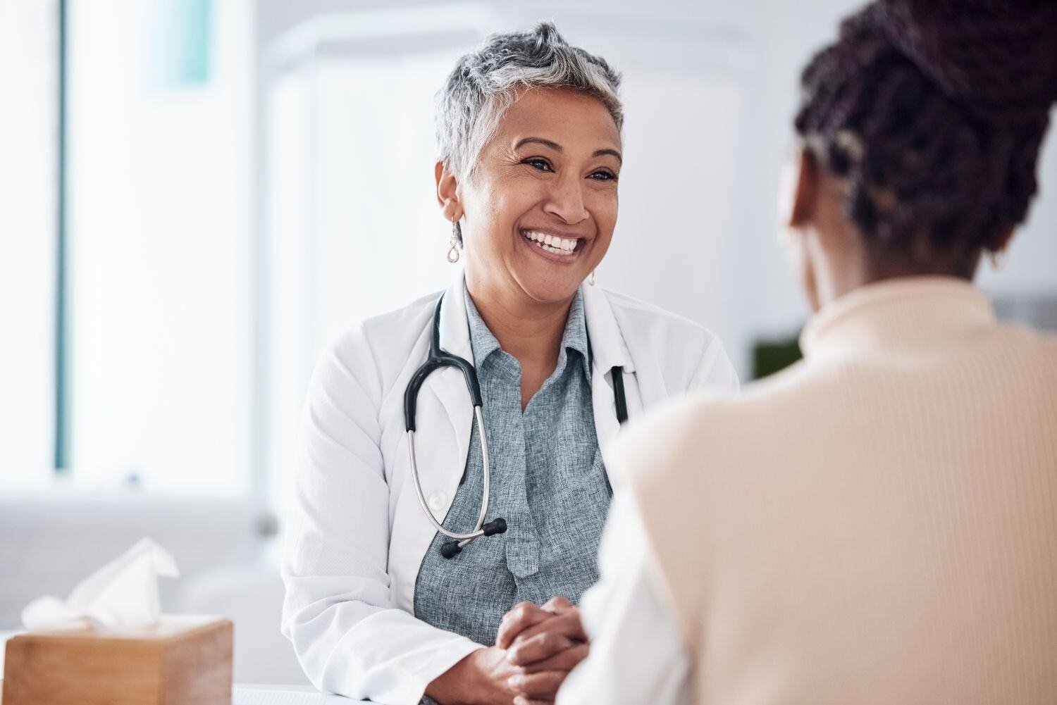 Smiling female doctor consulting with a patient in a hospital.