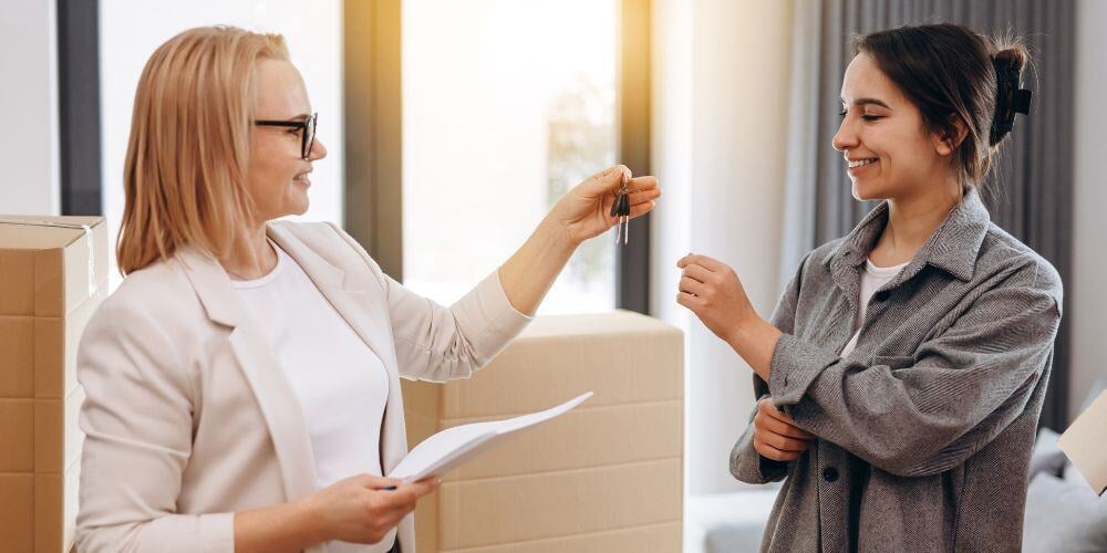 Property agent giving a key of apartment to new owner